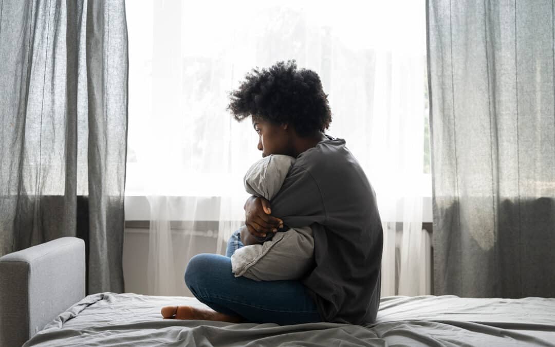 Young woman sitting on beg hugging a pillow