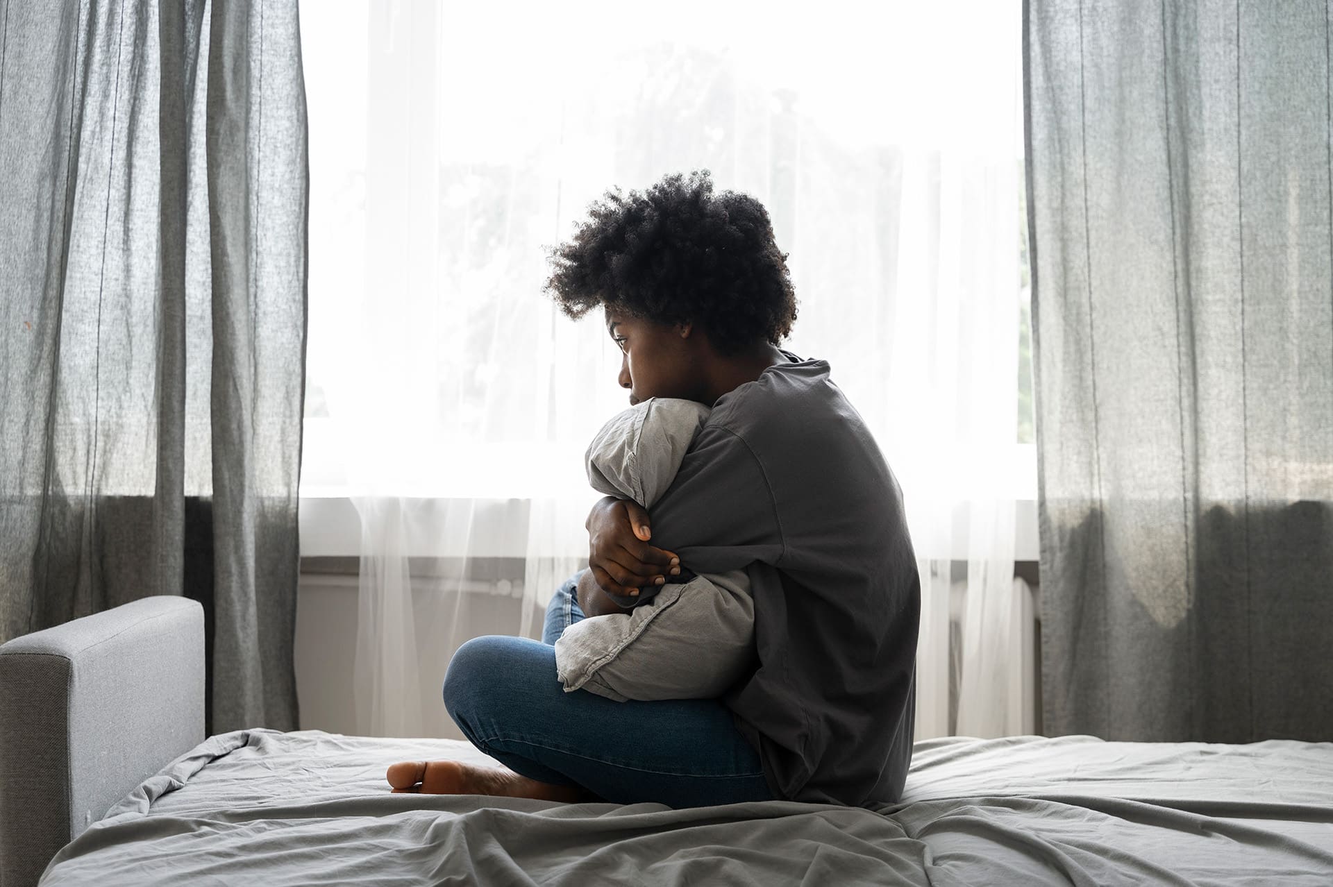 Young woman sitting on beg hugging a pillow